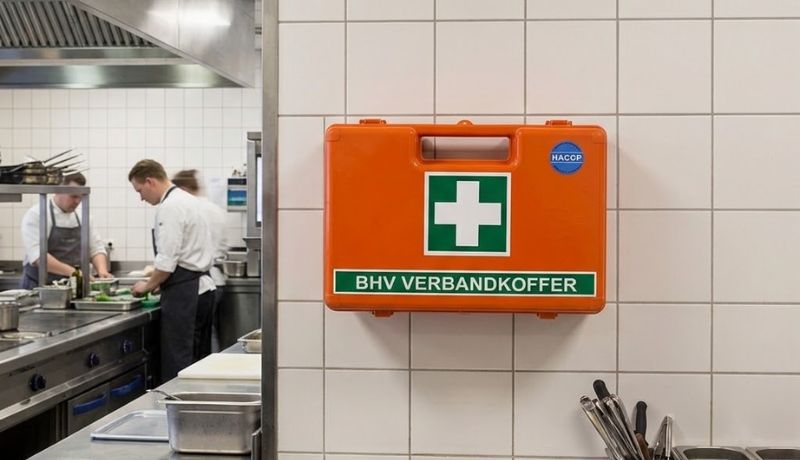 EHBO-koffer voor horeca aan de wand in een professionele keuken