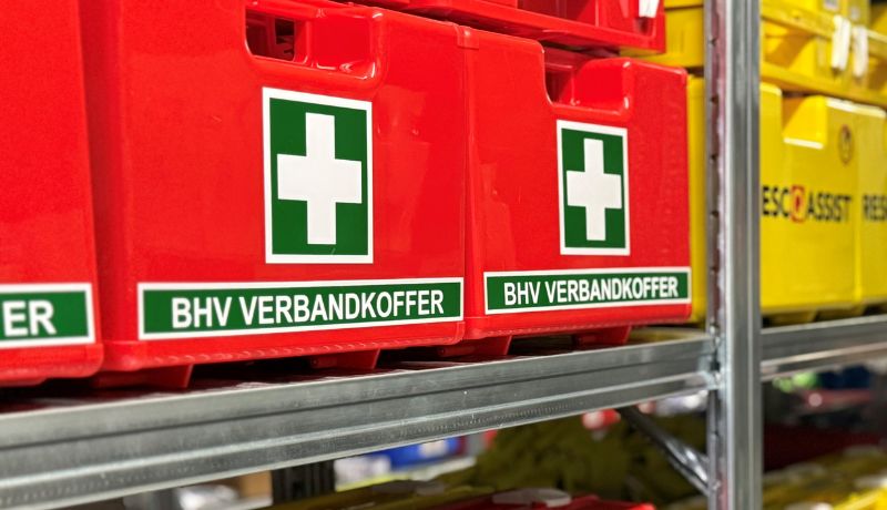 BHV verbandkoffers met het Oranje Kruis logo naast elkaar in het magazijn