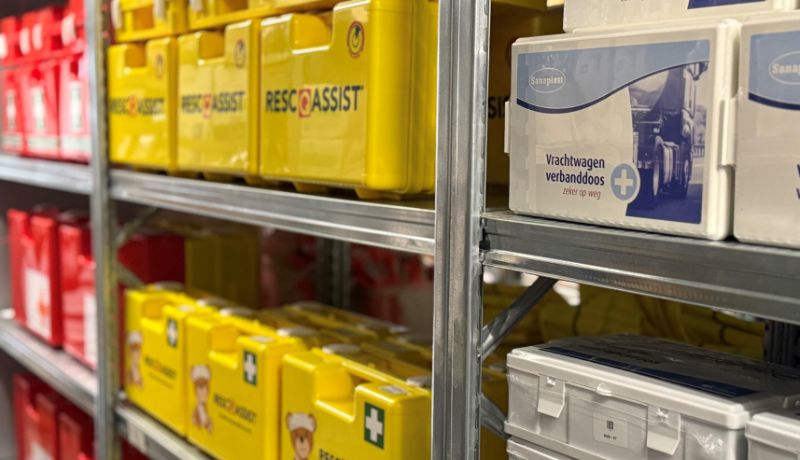 Rescue-Assist verbandkoffers en verbandtrommels naast elkaar in het magazijnschap